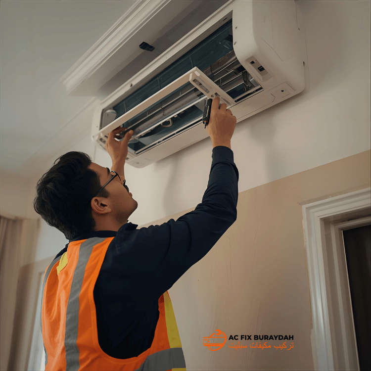 فني يقوم بإصلاح وحدة تكييف سبليت مثبتة على الحائط في منزل سعودي، باستخدام الأدوات ومعدات السلامة